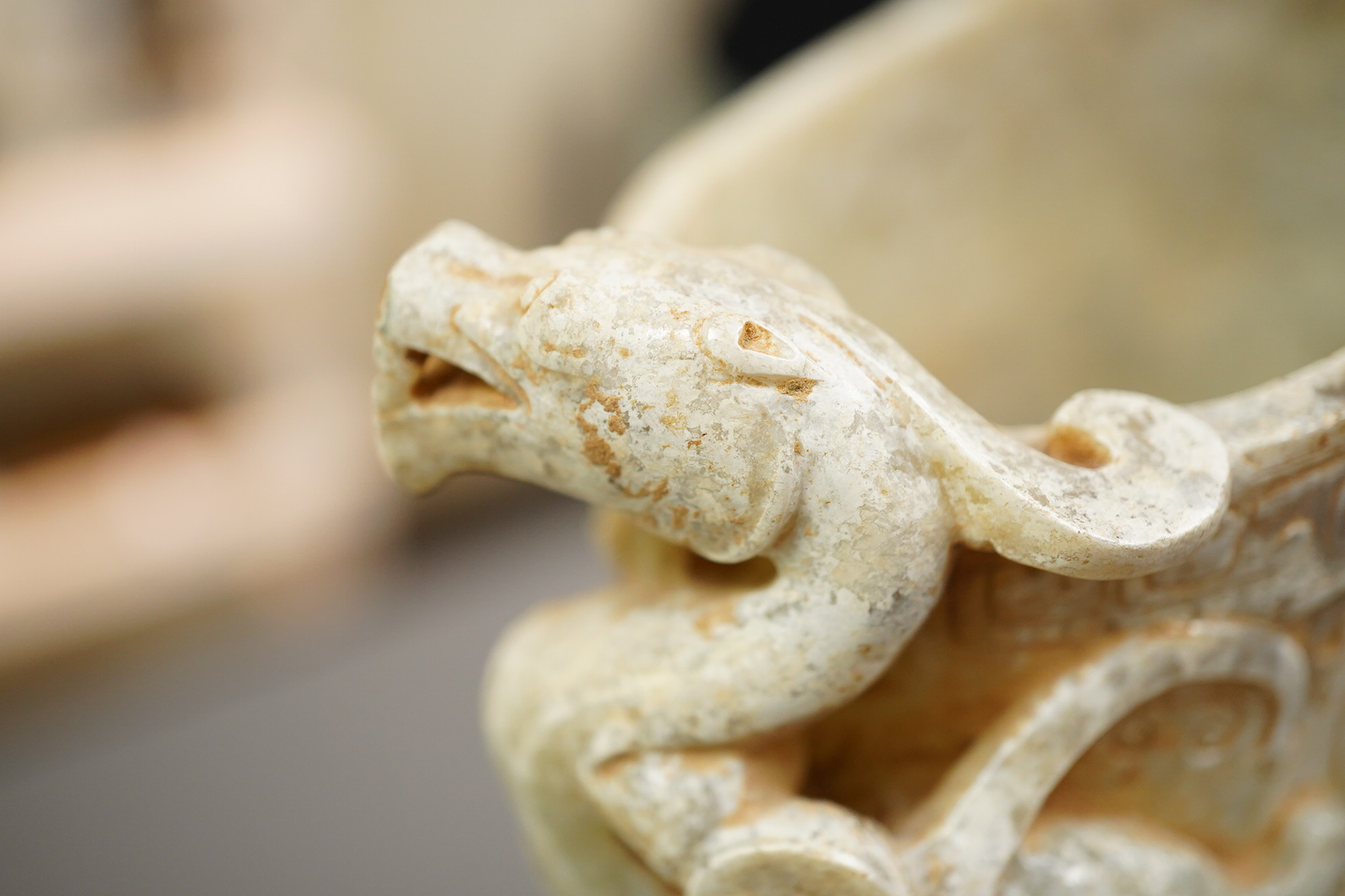 A large Chinese archaistic pale celadon and calcified jade rhyton